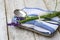 Closeup shot of a silver fork, spoon and lavender flowers laid on a towel tied with a thread