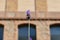 Closeup shot of a single lavender in front of a building