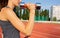 Closeup shot of slender sporty woman doing exercises with the dumbbells at the stadium. Empty space