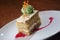 Closeup shot of a slice of carrot cake and a scoop of pistachio ice cream on a white plate