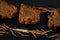 Closeup shot of slices of freshly baked carrot cake with strips on a dark surface