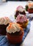 Closeup shot of small cupcakes with colorful creams on a towel