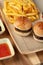 Closeup shot of small hamburgers, fries, and sauces