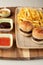 Closeup shot of small hamburgers, fries, and sauces