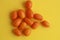 Closeup shot of small kumquat fruits on a yellow background