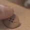 Closeup shot of a small sewing button on a human finger with a blurred background