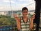 Closeup shot of a smiling male wearing sleeveless shirt showing peace sign on a cable ropeway