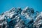 Closeup shot of snow covered jagged mountain peaks under clear blue skies