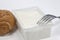 Closeup shot of soft cheese of bovine stracchino with a tray, bread on a white isolated background