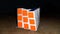 Closeup shot of a solved Rubik\'s Cube on a wooden surface with black background