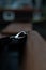 Closeup shot of a stainless carabiner of a rope hanging in wood against blur background