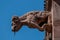 Closeup shot of a stone sculpture of the Freiburger Munster cathedral against a blue sky.