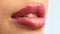 Closeup shot stylist applies lipstick  to the lips of the female model. Woman making make up applying lipstick on a lip.