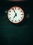Closeup shot of a subway wall clock showing the time. four minutes to seven