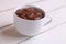 Closeup shot of the sweet melted chocolate in the cup on the wooden surface