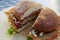 Closeup shot of a tasty cheeseburger cut in half on a wooden board