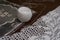 Closeup shot of textile cotton yarn, needle, and filet crochet on a wooden surface