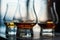 Closeup shot of three glasses of whiskey on blurred background