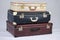 Closeup shot of three leather suitcases on a white background