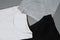 Closeup shot of three monochrome black, white and gray cotton t shirts. Flat lay tees template