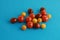 Closeup shot of three types of cherry tomatoes on a blue surface