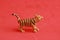 Closeup shot of tiger shape plastic toy isolated on a red background