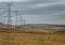 Closeup shot of transmission towers in the field under a cloudy sky