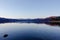 Closeup shot of trees and hills reflected in the calm lake