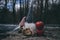 Closeup shot of two cute garden gnomes, red apples and a piece of bread on the ground