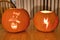 Closeup shot of two orange pumpkins carved for Halloween and lit with small candles placed inside