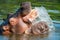 Closeup shot of two playful hippos frolicking in the water