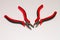 Closeup shot of two red precision cutter pliers isolated on a white background