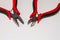 Closeup shot of two red precision cutter pliers isolated on a white background