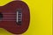 Closeup shot of a ukulele soundboard part on a yellow background