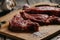 Closeup shot of uncooked steak with a pinch of salt on a wooden board surface