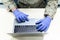 Closeup shot of uniformed military male with medical gloves using his laptop