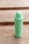 Closeup shot of a used green crayon on the bench