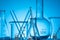 Closeup shot of a variety of glass flasks and lab equipment on a blue background