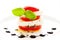 Closeup shot of a vertical Caprese salad with basil on a white plate