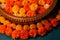 Closeup shot of vibrant orange and yellow floral decorations and candles for Diwali