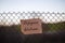 Closeup shot of a white paper with Refugees Welcome text hanging from a wired fence