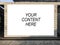 Closeup shot of a white screen with the text your content here