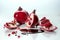 Closeup shot of whole and cut pomegranates and pomegranate juice on a white background