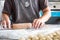 Closeup shot of a woman rolling dough in a kitchen filled with rolls of dough