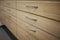 Closeup shot of wooden drawers with thin metal handles