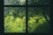 Closeup shot of a wooden window with cobwebs on the glass, overlooking a green garden