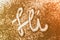Closeup shot of the word Hi` written in calligraphy on a brown sand`