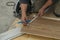 Closeup shot of a worker measures and saws off fragments of steps for stairs in the house