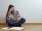 Closeup shot of a worried young  Caucasian female reviewing documents and checking invoices at home