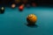 Closeup shot of the yellow billiard ball in a green pool table